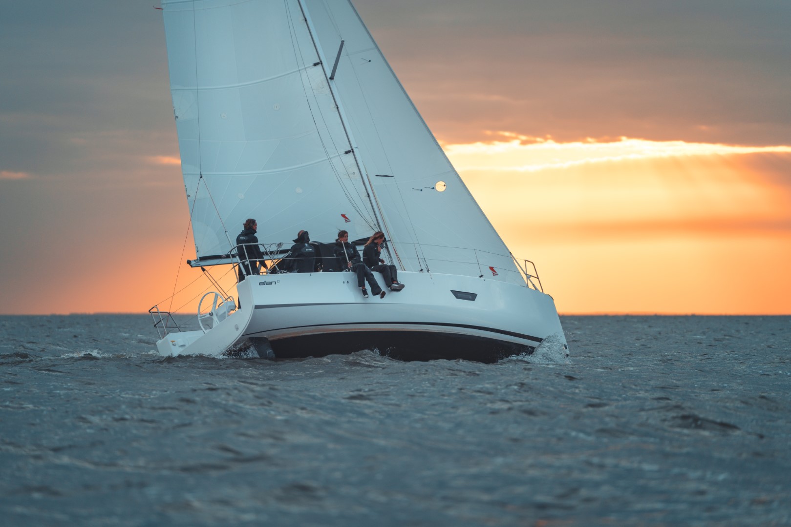 elan-yachts-e3-performance-cruiser-sailboat-sailing-at-sunset-heeled