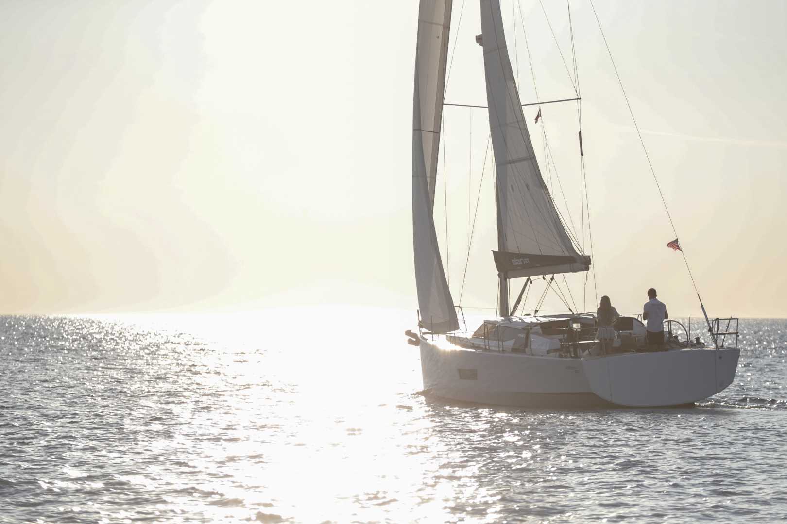 Elan GT5 luxury performance cruiser sailing close hauled at sunset, port quarter view